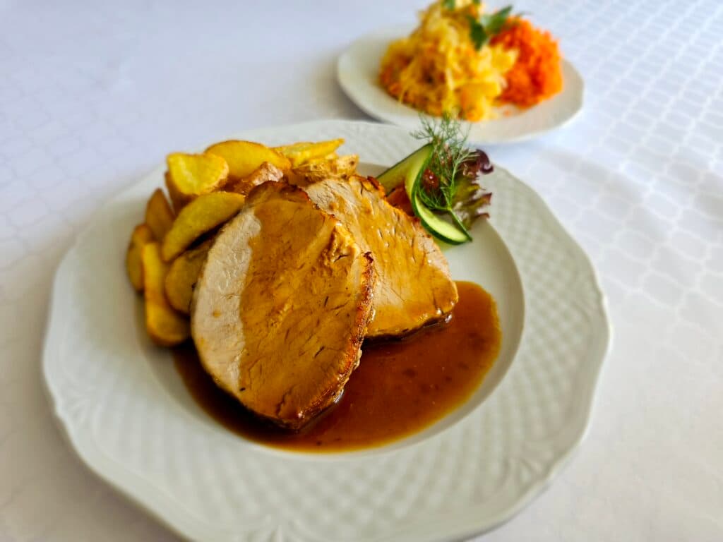 Obiady weselne w Restauracji Grand Felix — pieczeń z dodatkami podana na stole bankietowym